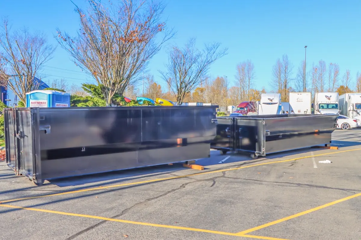 Professional dumpster rental service with roll-off container on residential driveway in Old Jamestown